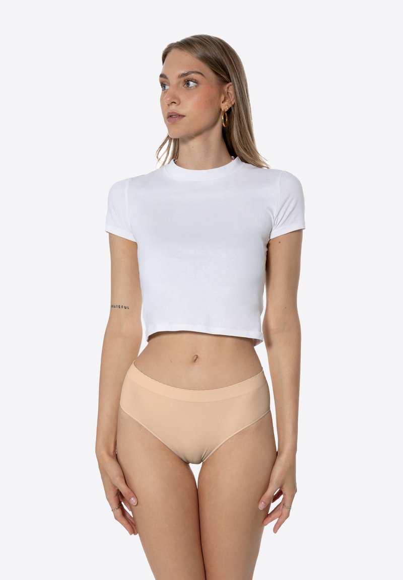 T-shirt blanc court à manches courtes, associé à un sous-vêtement beige taille haute sans couture. Texture lisse, design minimal.