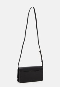 Schwarze Leder-Crossbody-Tasche mit glatter Textur, gefaltetem Design, verstellbarem Riemen und minimalistischem Stil. Misst ungefähr 25 cm in der Breite.