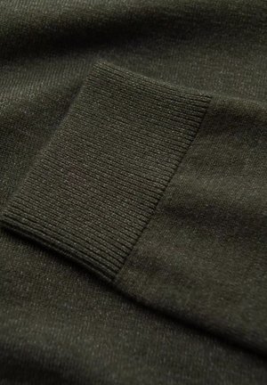Tejido de suéter verde oscuro con un detalle de puño acanalado. La textura parece suave y ligeramente texturizada, mostrando un acabado de costura fina.