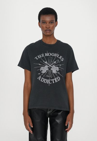 Tricou din bumbac negru cu un imprimeu grafic ce conține textul "THE KOOPLE'S ADDICTED" în argintiu, cu mâneci scurte și o croială relaxată.