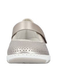 Beige leather Mary Jane shoe with perforated design, cushioned interior, and a white rubber sole. Features a wide strap for secure fit.