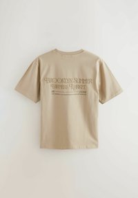 T-shirt en coton beige à manches courtes. Il présente un texte au dos : « BROOKLYN SUMMER FARMERS MARKET 09 JUIN » dans une police stylisée.