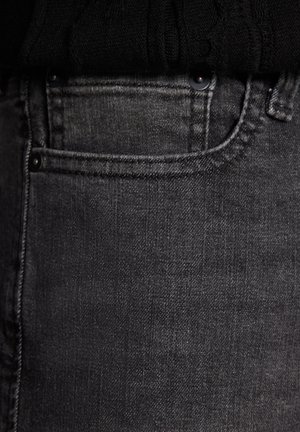 Mustat farkut klassisella mitoituksella, joissa on etutasku, huomaamaton ommel ja sileä, tasainen pinta.