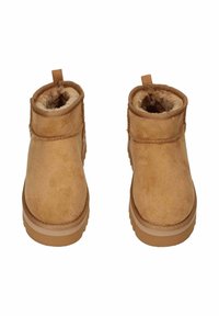 Un paio di stivali in suede beige per l'inverno con rivestimento in morbido shearling e suole in gomma, mostrati frontalmente su uno sfondo bianco.