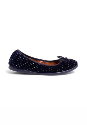 Ballerines en velours bleu marine avec de petits points blancs, bout arrondi, accent nœud à l'avant et semelle en caoutchouc flexible.