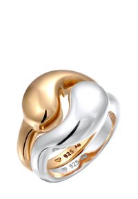 Twee-kleurige ring met onderling verweven vormen in gepolijst geelgoud en zilver, met zichtbare metalen zuiverheidmerken aan de binnenkant.