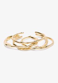 Bracelets en métal doré, présentant un design torsadé avec une finition lisse. Quatre tailles variées avec une surface polie et réfléchissante.