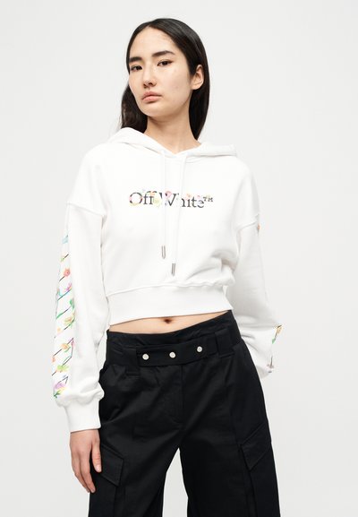 Λευκό cropped φούτερ με κουκούλα, λογότυπο Off-White με λουλουδένιο σχέδιο, κορδόνι στην κουκούλα και πολύχρωμα λουλουδένια σχέδια στα μανίκια. Συνδυάζεται με μαύρο ψηλόμεσο παντελόνι.