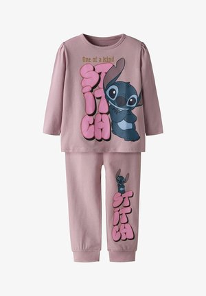 Ensemble composé d'un haut à manches longues et d'un pantalon rose poussiéreux, avec le personnage Stitch et le texte "One of a kind Stitch" en lettres bulle roses.