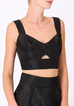 Top court noir en satin avec des bretelles larges, fronces à l'avant, une ouverture en forme de trou de serrure à la taille et une coupe ajustée.