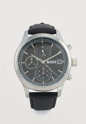 Montre pour homme avec bracelet en cuir noir, cadran noir, boîtier argenté, sous-cadrans chronographes, affichage de la date, et aiguilles argentées indiquant 10:09:37.