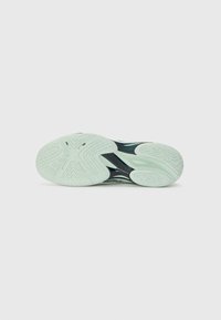 Shoe sole with a textured rubber surface in light mint green. Features grooves and circular patterns for traction and grip.