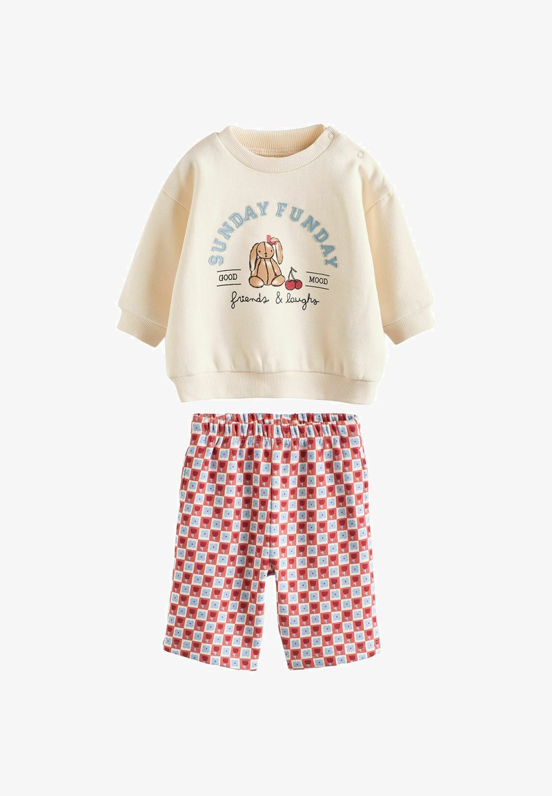 Sweatshirt crème avec un graphique de lapin et le texte "SUNDAY FUNDAY", associé à un short à motifs rouges et bleus comportant des carrés et des ours.