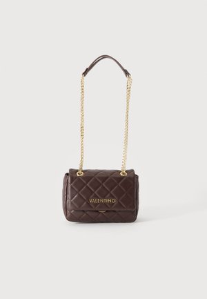 Σκούρα καφέ καπιτονέ τσάντα Valentino με χρυσή αλυσίδα και χρυσό λογότυπο μπροστά, τοποθετημένη σε λευκό φόντο.