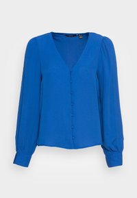 Blouse bleue à manches longues avec un col en V, dotée d'une fermeture boutonnée à l'avant et de manches bouffantes froncées. Tissu lisse et léger.