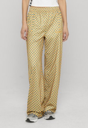 Pantalon jaune à motif pied-de-poule bleu, avec une ceinture élastique et des poches latérales. Tissu léger, coupe large.