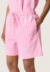 Rosa randiga shorts med en texturerad kvalitet, elastisk midja och dragsko. Har sidfickor och en avslappnad passform för komfort.