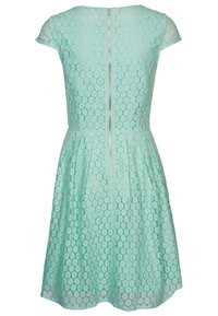 Mintgrön spetsklänning med korta kap sleeves, figursydd bodice, utsvängd kjol, blommönster och en dold bakdragkedja.