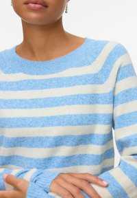 Lichtblauwe en crèmekleurige gestreepte sweater met een geribbelde halslijn en manchetten. Zachte textuur, met horizontale strepen en een ontspannen pasvorm.