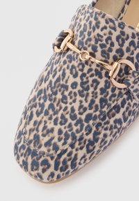 Flat παπούτσια με λεοπάρ σχέδιο και στρογγυλή μύτη, διαθέτουν διακοσμητική αλυσίδα σε χρυσό τόνο. Μαλακή υφή από σουέτ με διακριτές ραφές.