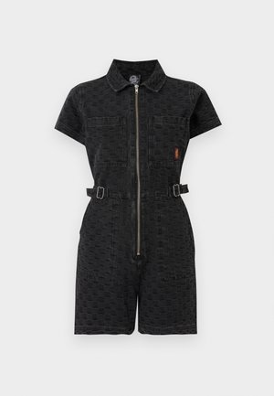 Černý kostkovaný krátký overal s krátkými rukávy, předním zipem, límečkem, dvěma kapsami na hrudi a nastavitelnými pásky na bocích.