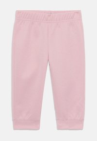 Pantaloni della tuta rosa chiaro con vita elastica, polsini affusolati e una superficie liscia, senza motivi o componenti visibili.