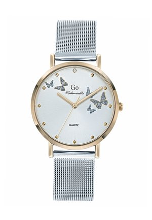 Montre en quartz dorée avec un cadran bleu clair, des accents en forme de papillon, un bracelet en maille argentée et des détails dorés avec des index horaires ronds.