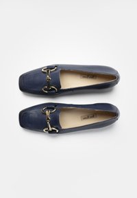 Mocassini in pelle blu navy con punta quadrata, presentano un dettaglio in metallo dorato nella parte anteriore e una finitura liscia. Interno foderato.