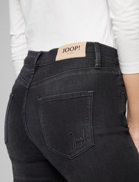Schwarze Jeans aus Denim mit einem Lederschild an der Taille, das mit "JOOP!" gebrandet ist, und einer Gesäßtasche mit gesticktem Logo-Detail.
