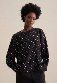 Maglietta nera a maniche lunghe con un motivo floreale multicolore, caratterizzata da un collo rotondo e una vestibilità comoda. Texture morbida con dettagli delle maniche arricciati.