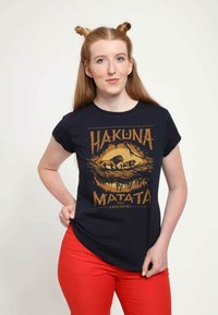 Černé bavlněné tričko s grafikou "Hakuna Matata" ve zlaté barvě, zobrazující lvy z Lvího krále, krátké rukávy a zaoblený výstřih.