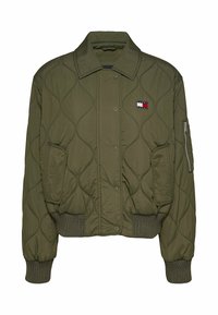 Chaqueta bomber acolchada en verde oliva con botones a presión, puños acanalados y un pequeño parche con logotipo. Cuenta con bolsillos laterales y un bolsillo con cremallera en la manga.