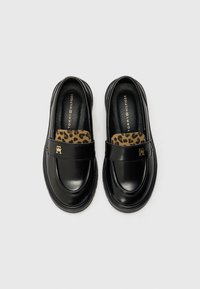Svarta lackläder loafers med leopardmönstrade detaljer och guldhardware. Rundad tå och texturerad sidopanel.