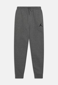 Pantalones de chándal grises hechos de un tejido suave, con una cinta elástica en la cintura y un cordón, además de un logo de Jordan en negro en el muslo izquierdo.