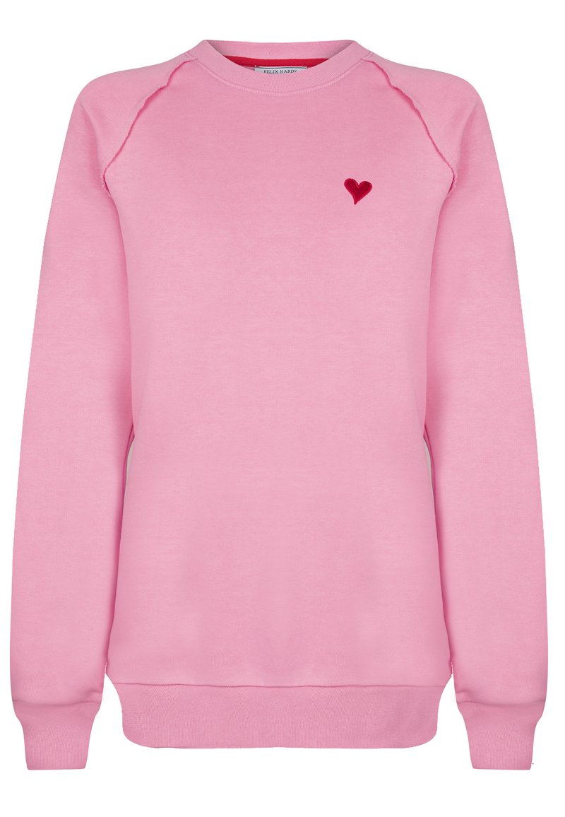 Rosa sweatshirt med rund halsringning, raglanärmar, ribbade muddarna och nederkant, med en liten röd hjärtapplikation på vänster bröst.