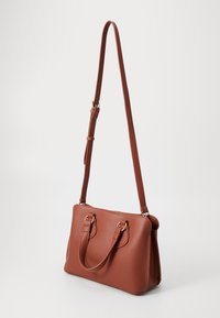 Sac à main en cuir texturé marron avec des poignées doubles et une bandoulière amovible. Accents en métal doré et fermeture éclair. Forme rectangulaire compacte.