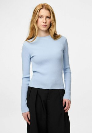 Top bleu clair à manches longues côtelé avec col rond et coupe ajustée, associé à un pantalon noir taille haute avec des plis.
