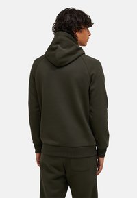Dunkelgrüner Kapuzenpullover aus Baumwollmix, mit gerippten Bündchen und Saum, glatter Textur, seitlichen Eingrifftaschen und einem lockeren Schnitt.