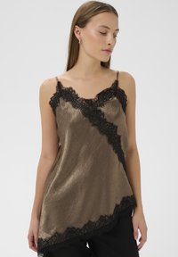 Brun satincamisole med sort blonderkant, der har tynde justerbare stropper og asymmetrisk kant. Struktureret stof med diskret glans.