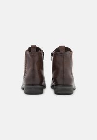 Stivali ankle in pelle marrone con pannello laterale texturizzato, tacco basso a blocco e chiusura con zip, dotati di tiranti posteriori.