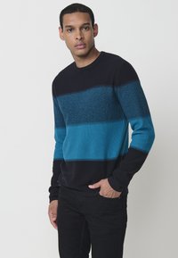 Vīriešu adīts džemperis ar horizontālām svītrām tumši zilā un tirkīza krāsā, apaļš kakls un garas piedurknes. Audumam ir teksturēta virsma.