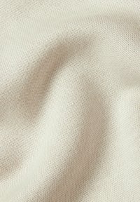 Light beige knit fabric featuring a textured weave with a soft, slightly stretchy appearance. No visible patterns or accents.