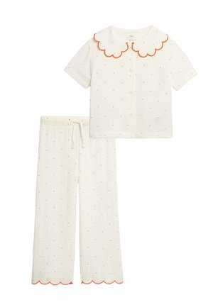 Biały dwuczęściowy zestaw piżam z krótkim rękawem, zapinanym na guziki oraz spodniami z elastycznym pasem, ozdobiony małymi czerwonymi kropkami i pomarańczowymi falistymi brzegami.
