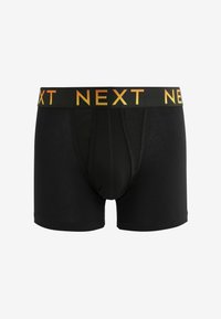 Must männi boxerid mustast puuvillast, millel on kontrastne must ja oranž elastne vöö, millel on suurtes tähtedes kiri "NEXT". Üksikasjalikud siledad õmblused.
