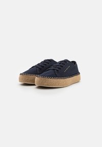 Marinblå kanvas sneakers med runda tår, platta snören och en sula inlindad i jute. Inkluderar diskret varumärkning och texturerade sömnadsdetaljer.