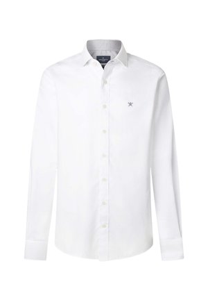 Biela košeľa s dlhým rukávom a gombíkmi, s ostrým golierom a malým vyšitým logom na ľavej strane hrude, zobrazená na jednoduchom pozadí.