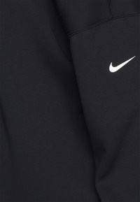 Sweat-shirt noir en tissu doux, avec un col rond et un logo Nike blanc sur le côté gauche de la poitrine. Coupe régulière, sans motifs apparents.