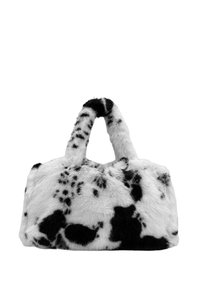 Sac à main en fausse fourrure à imprimé vache noir et blanc, avec une forme arrondie et deux petites poignées, présentant une texture douce et des taches prononcées.
