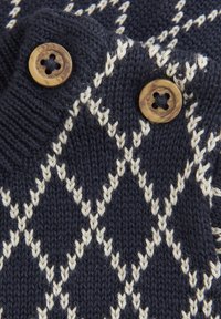 Marineblauer Strickpullover mit einem Diamantmuster in Creme, ausgestattet mit zwei braunen Knöpfen mit vier Löchern am Kragen zum Verschließen.