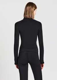 Top nero a maniche lunghe realizzato in tessuto elasticizzato, con colletto alto e design aderente. Dettagli delle cuciture lungo le spalle e la schiena.